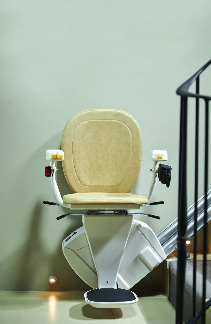 Gerader Treppenlift frontal an einer Innentreppe mit vollständig sichtbarem Fußbrett