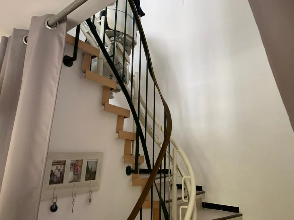 Zweirohr-Fahrschiene eines Kurventreppenlifts entlang einer gewendelten Treppe